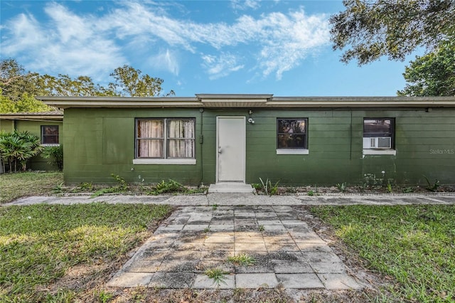 ranch-style house featuring a front yard and cooling unit