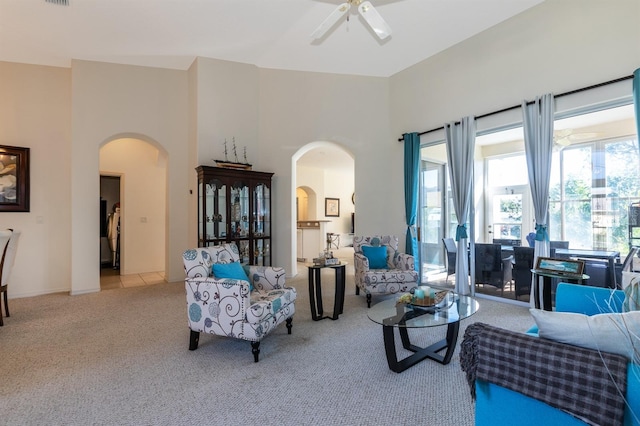 living room with light carpet, a high ceiling, and ceiling fan