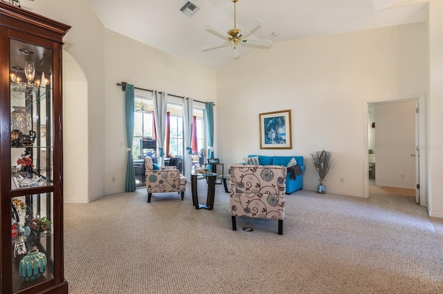 living area featuring ceiling fan, light carpet, and high vaulted ceiling