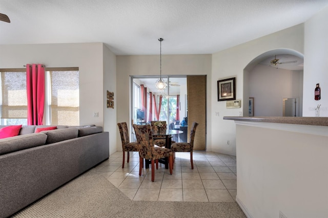 dining room with ceiling fan, light tile patterned floors, and a textured ceiling