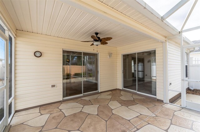 unfurnished sunroom with ceiling fan, a healthy amount of sunlight, and wood ceiling