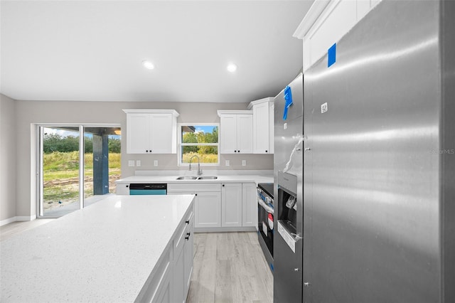 kitchen with white cabinetry, light stone countertops, light wood-type flooring, sink, and stainless steel appliances