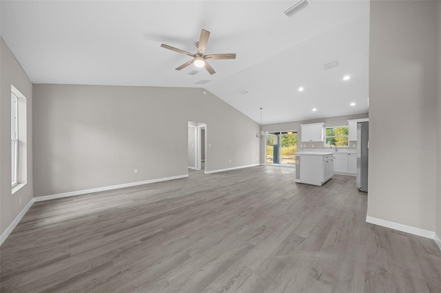 unfurnished living room featuring ceiling fan, lofted ceiling, and light hardwood / wood-style flooring