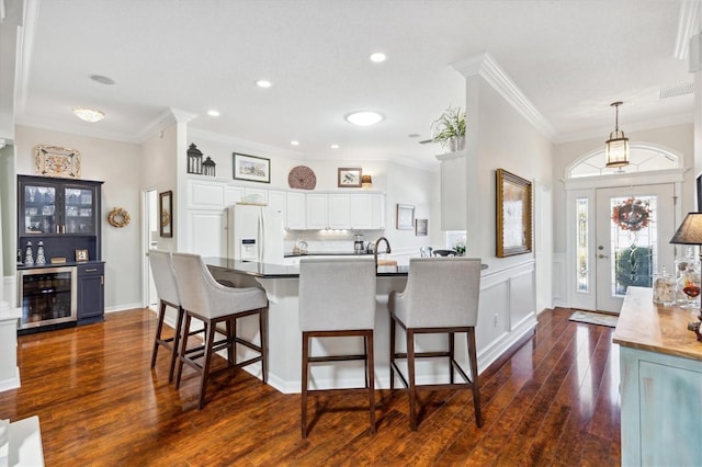 kitchen with wine cooler, white cabinets, dark hardwood / wood-style flooring, crown molding, and white refrigerator with ice dispenser