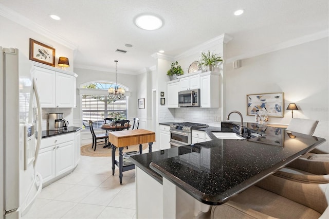 kitchen featuring kitchen peninsula, hanging light fixtures, stainless steel appliances, and sink