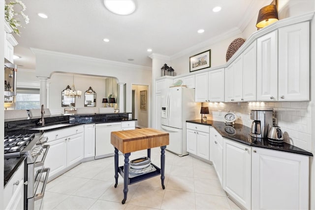 kitchen featuring white cabinets, decorative columns, ornamental molding, sink, and white appliances