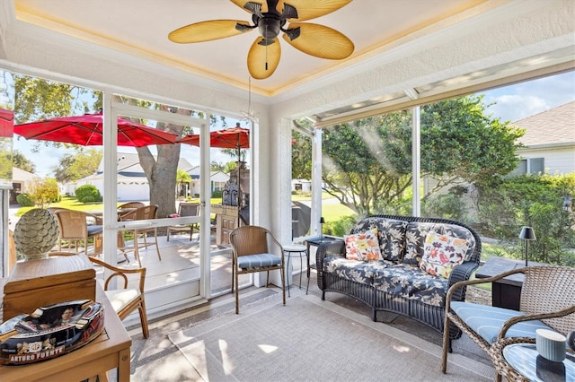 sunroom featuring ceiling fan and a raised ceiling