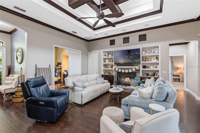 living room featuring crown molding, a fireplace, dark hardwood / wood-style floors, and built in features