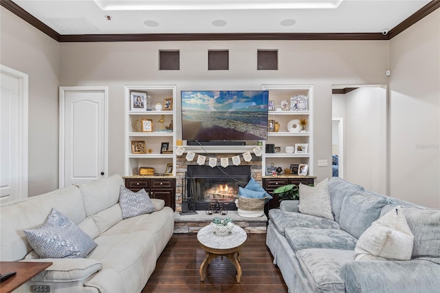 living room with ornamental molding, a stone fireplace, dark wood-type flooring, and built in features