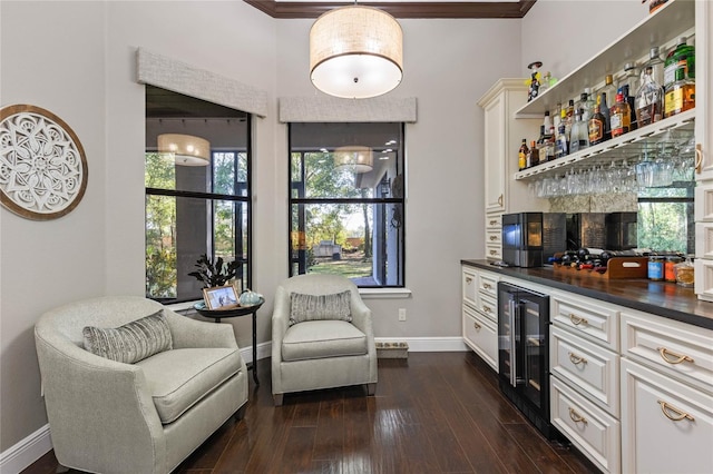 bar with white cabinetry, crown molding, dark wood-type flooring, and beverage cooler