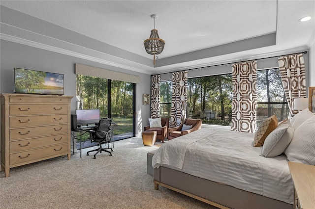 carpeted bedroom featuring ornamental molding, a raised ceiling, and access to outside