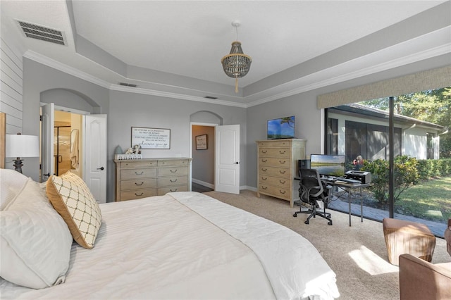 carpeted bedroom with access to outside and a raised ceiling