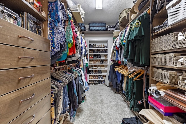 walk in closet featuring light carpet