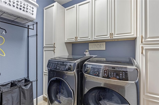 laundry area with cabinets and washer and clothes dryer