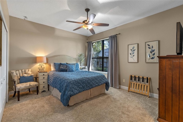 carpeted bedroom featuring ceiling fan, a closet, and a textured ceiling