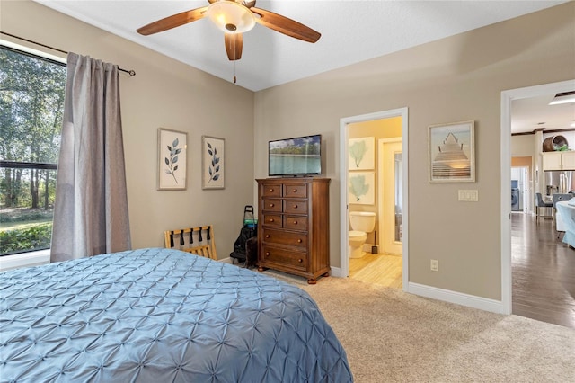 bedroom with ceiling fan, carpet flooring, connected bathroom, and stainless steel refrigerator with ice dispenser