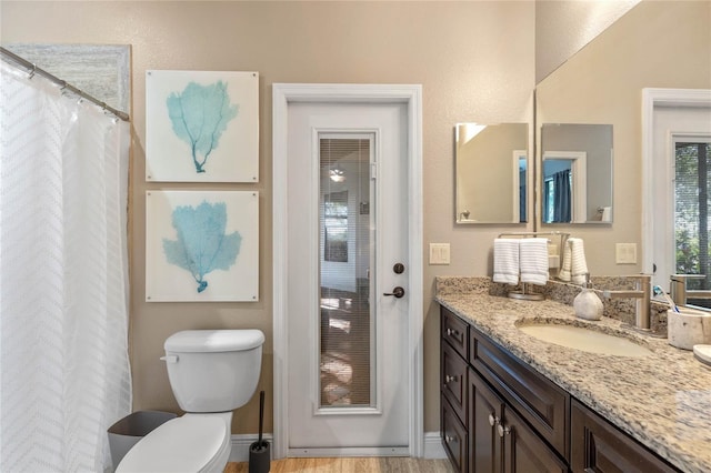 bathroom featuring wood-type flooring, vanity, and toilet