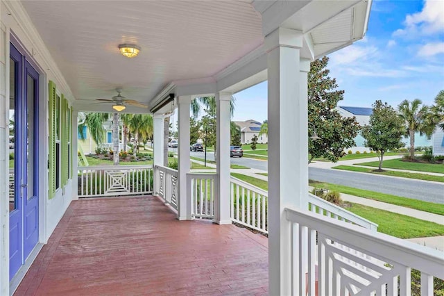 wooden terrace featuring ceiling fan and a porch