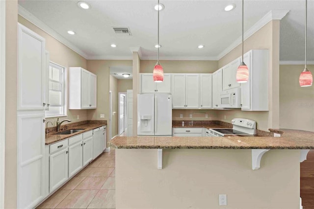 kitchen featuring pendant lighting, white appliances, and a breakfast bar area