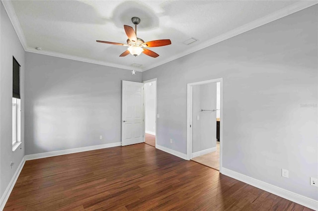 spare room with dark wood-type flooring, ceiling fan, and ornamental molding