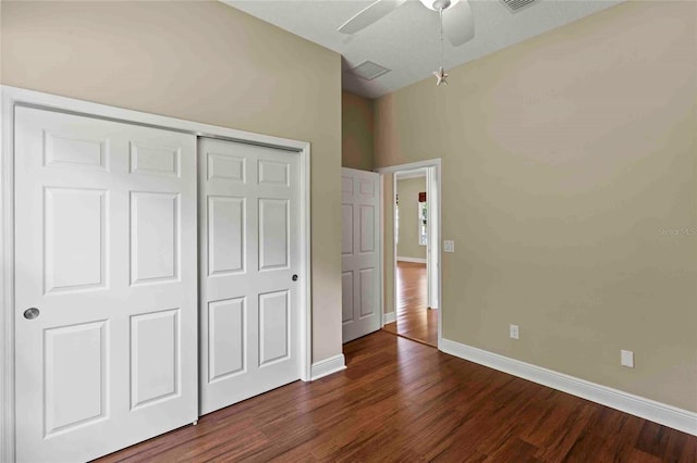 unfurnished bedroom featuring ceiling fan, a closet, and dark hardwood / wood-style flooring