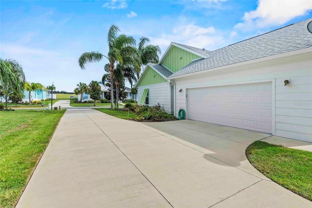 view of side of property featuring a garage and a yard