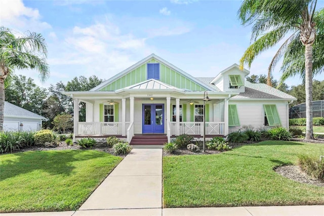 view of front of home with a front lawn, french doors, and covered porch