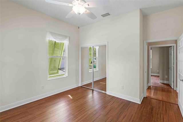 unfurnished bedroom featuring ceiling fan, a closet, and dark hardwood / wood-style flooring