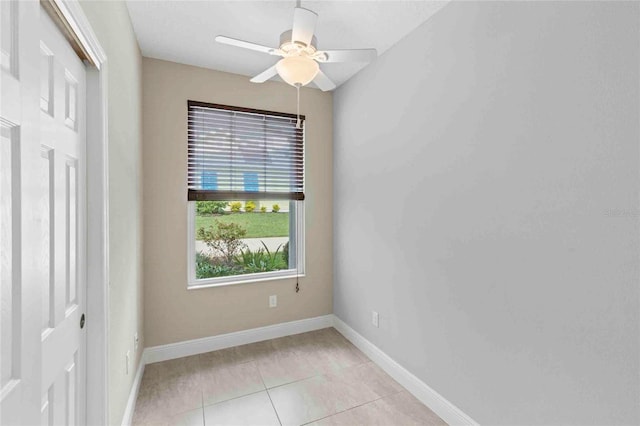 tiled empty room featuring ceiling fan