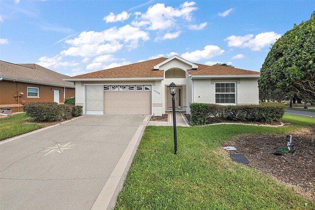 single story home featuring a front yard and a garage