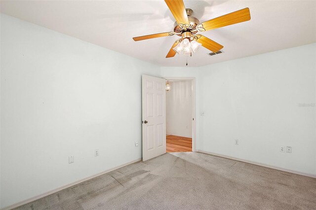 carpeted spare room with ceiling fan