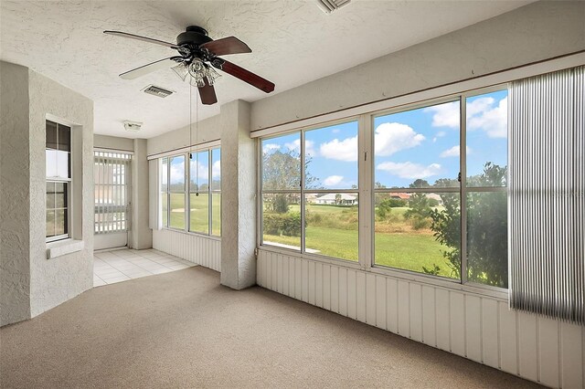 unfurnished sunroom with a healthy amount of sunlight and ceiling fan