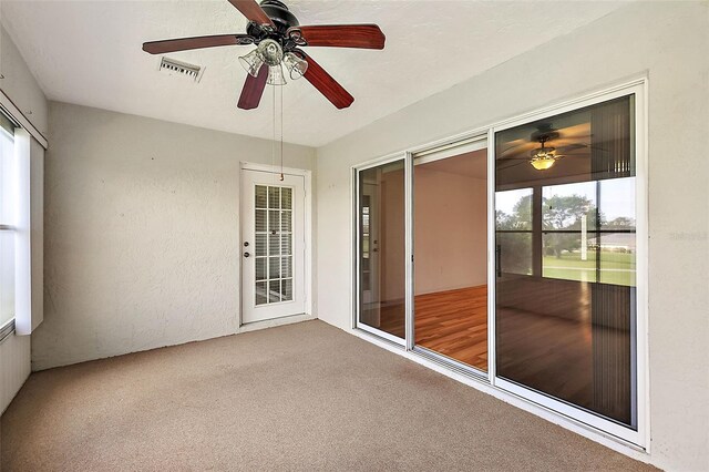 unfurnished sunroom with ceiling fan