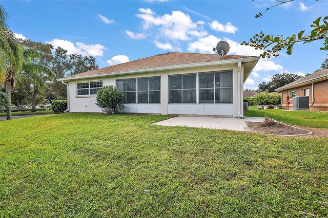 rear view of house featuring a patio, a sunroom, a lawn, and cooling unit