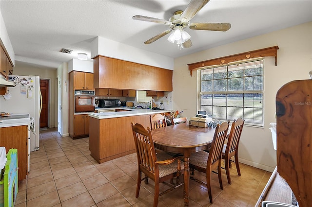 dining room with a textured ceiling, light tile patterned floors, and ceiling fan