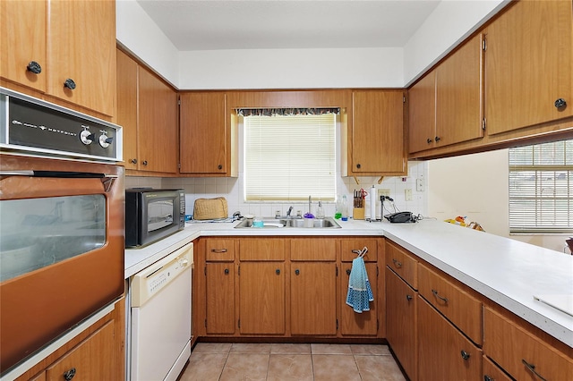 kitchen with sink, black appliances, decorative backsplash, and light tile patterned floors