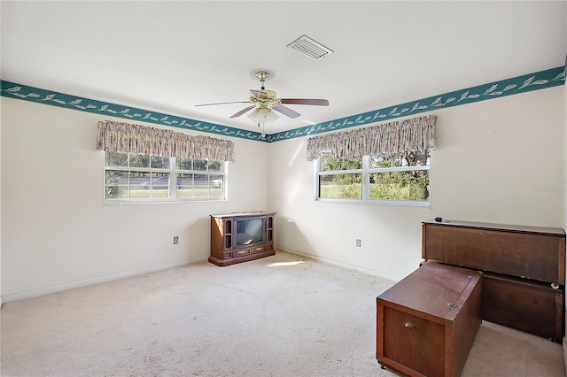 misc room with light colored carpet and ceiling fan