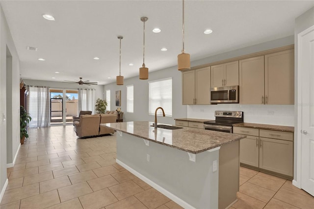 kitchen with an island with sink, stainless steel appliances, sink, pendant lighting, and ceiling fan