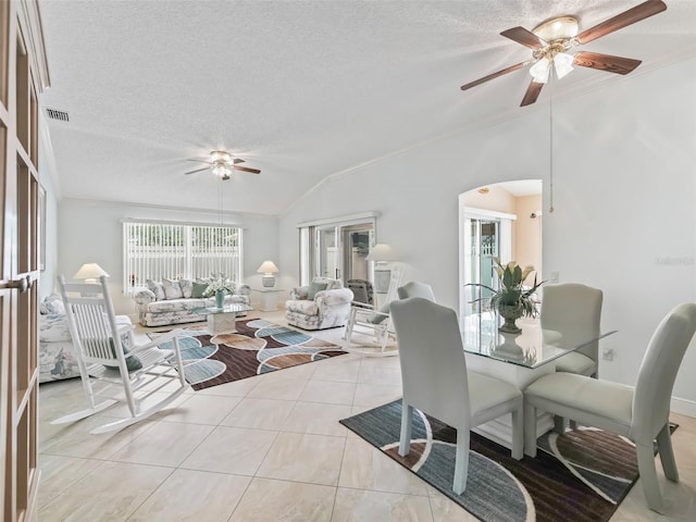 living room featuring vaulted ceiling, ceiling fan, a textured ceiling, and light tile patterned flooring