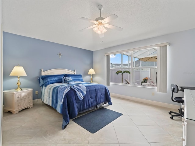 bedroom featuring a textured ceiling, light tile patterned floors, and ceiling fan