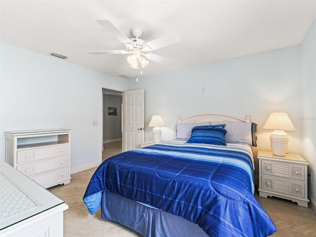 tiled bedroom featuring a textured ceiling and ceiling fan