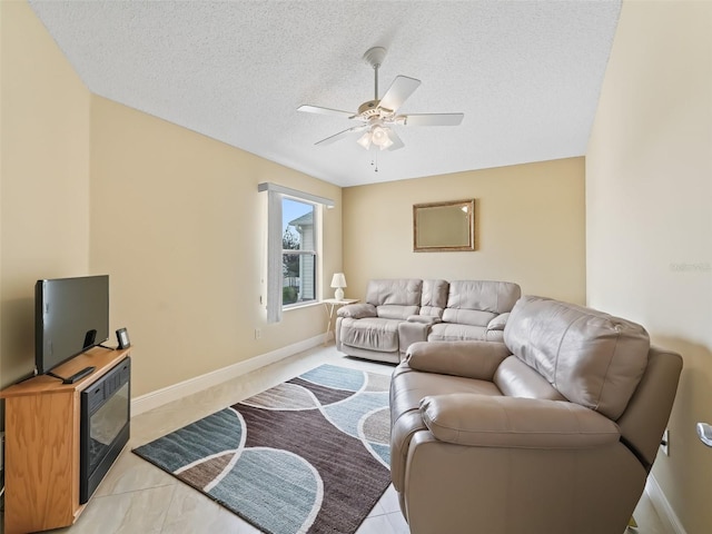 living room with a textured ceiling, light tile patterned flooring, and ceiling fan