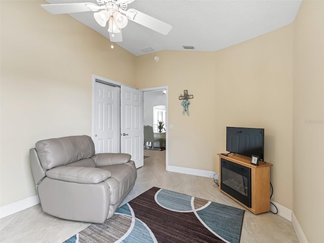 living room with ceiling fan, a textured ceiling, and vaulted ceiling