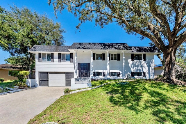 raised ranch featuring a front yard and a garage