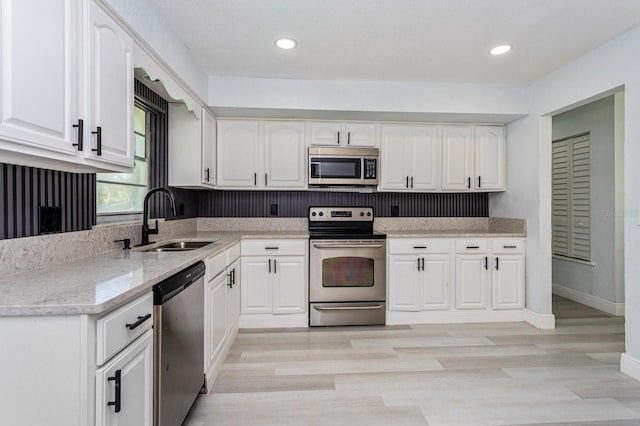 kitchen with stainless steel appliances, sink, and white cabinets