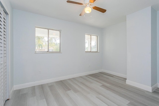 spare room with ceiling fan, light wood-type flooring, and a wealth of natural light