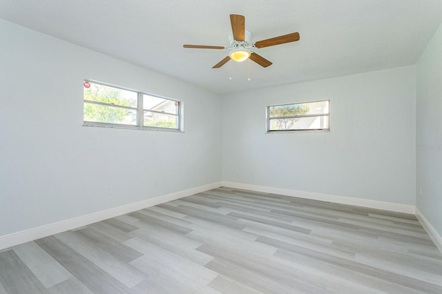 spare room featuring light hardwood / wood-style floors, ceiling fan, and a wealth of natural light