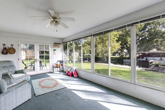 unfurnished sunroom with an AC wall unit and ceiling fan