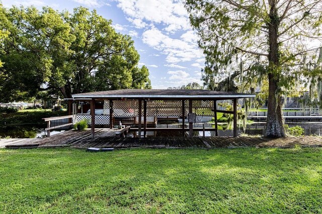 dock area with a lawn and a water view