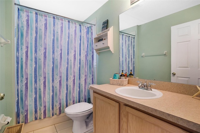 bathroom with toilet, vanity, and tile patterned floors